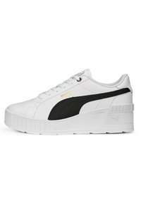 White sneaker with black accents and gold logo, featuring a textured synthetic upper and a thick platform sole. Lace-up design.
