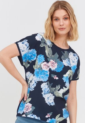 Blusenshirt mit kurzen Ärmeln, das blaue, pinke und weiße Blumen auf einem dunkelblauen Hintergrund zeigt. Hergestellt aus weichem Stoff mit lockerer Passform.
