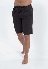 Czarne lniane szorty z elastycznym paskiem i sznurkiem do regulacji. Posiadają dwie boczne kieszenie i lekko teksturowane wykończenie.