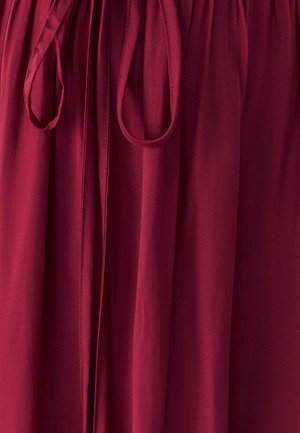 Burgundia kangas pehmea tekstuuriga, millel on kogutud vöökoht ja seotud pael. Õmbluse detailid on nähtavad üle kogu pikkuse.