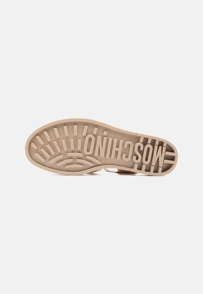 Semelle d'une chaussure Moschino beige avec des motifs texturés et le nom de la marque en relief sur toute la partie inférieure.
