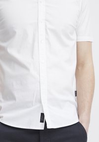 Korte mouw witte button-up shirt van katoen, met een klassieke kraag en een afgeronde zoom. Bevat merkmouwen aan de zijkant.