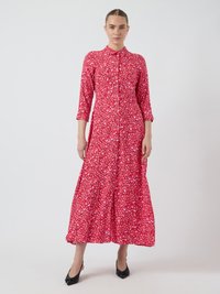 Robe longue rose à motifs floraux avec un col, un devant à boutons et des manches trois-quarts, en tissu léger et texturé.