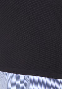 Tessuto nero con texture, con righe orizzontali nella parte superiore, che si trasforma in una sezione plissettata con strisce blu e bianche sottostante.