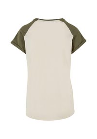 Kortermet T-skjorte med en kremfarget kropp og olivengrønne raglansleeves, med rund hals og et mykt, glatt stoff.