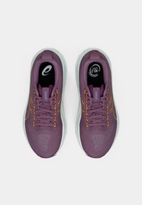 Vijolične športne čevlje z mrežastim zgornjim delom, oranžnimi akcenti in belimi podplati. Imajo podložene jezičke in vezalke za varen oprijem.