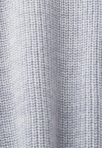 Lichtgrijze gebreide stof met een gestructureerd uiterlijk, met een consistent patroon van verweven garens. Zachte en buigzame textuur.