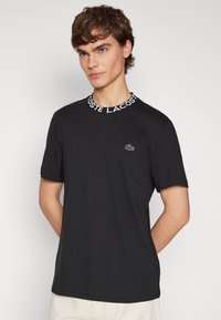 Lacoste CORE ACTIVE - Nyomott mintás póló - black