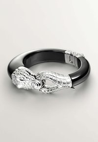 Cierre en diseño de serpiente plateada sobre una pulsera negra liscia, con un acabado brillante y escamas intrincadas en la cabeza y el cuerpo de la serpiente.