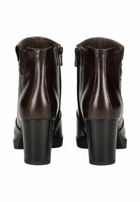Bottines en cuir marron avec un talon épais, dotées de deux fermetures éclair latérales et d'un détail de couture le long de l'arrière et des côtés. Texture lisse.
