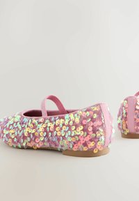Ballerine rosa ricoperte di paillettes multicolori, con tomaia in morbido tessuto e suola piatta in gomma. Fascetta elastica regolabile per una vestibilità ottimale.