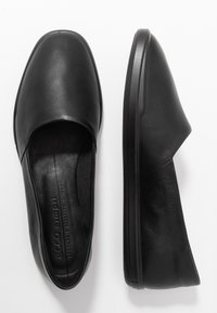 Chaussures en cuir noir à enfiler avec un bout arrondi, texture lisse, intérieur rembourré et semelle en caoutchouc noir flexible pour un confort optimal.
