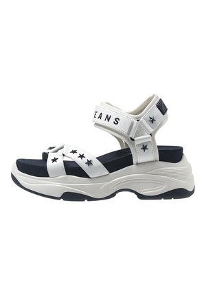 Witte platform sandalen met zwarte accenten, met kruisende banden, sterren op de banden en verstelbare enkelsupport voor een goede pasvorm.