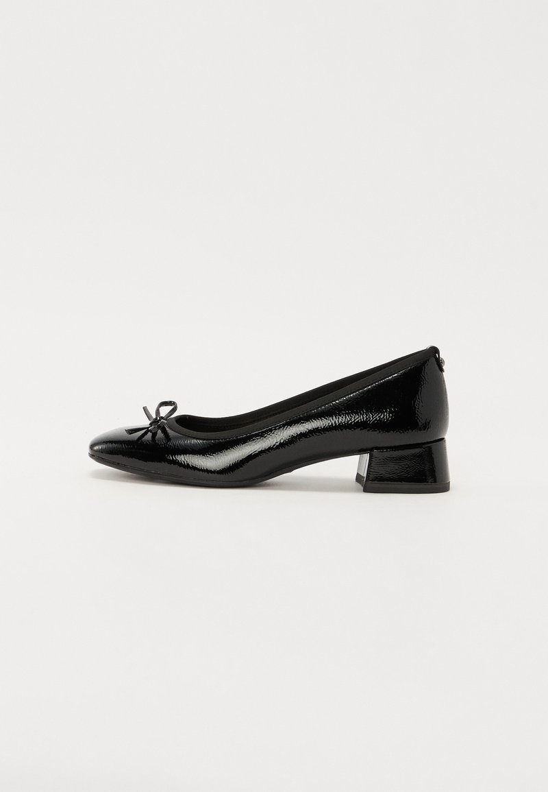 Escarpin en cuir verni noir à petit talon, bout rond, petit nœud décoratif à l'avant et talon bloc sur fond blanc uni.