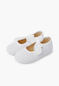 Weiße Baby-Schuhchen aus strukturiertem Stoff mit weichen Sohlen und transparenten Schleifenbändern, die oben gebunden sind, auf weißem Hintergrund präsentiert.