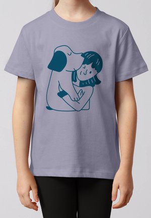 Enfant portant un t-shirt lavande avec une illustration bleue d'une fille câlinant et se faisant embrasser par un chien.