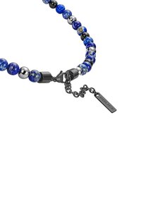 Bracciale di perline con perle sferiche blu e nere, accenti metallici e una chiusura con catena e un'etichetta rettangolare con la scritta "POLICE".