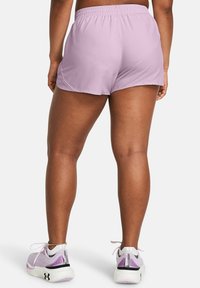 Ljuslila sportshorts med resårmidja, med en slät yta och lös passform, kombinerat med ljuslila löparskor.