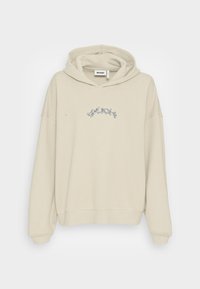 Haut à capuche couleur crème avec une capuche spacieuse, coupe ample et poignets côtelés. Présente un design graphique subtil en bleu sur le devant.