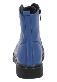 Botín de cuero azul con suela de goma negra texturizada, cierre de cremallera en la parte trasera y detalles de costura minimalistas.