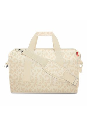 Sac polochon beige avec un subtil motif léopard, doubles poignées, bandoulière ajustable et fermeture éclair.