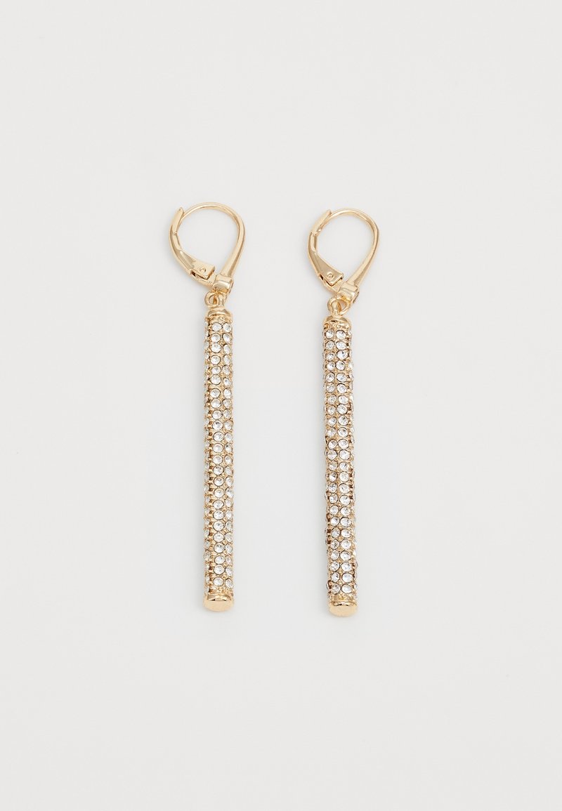 Paire de boucles d'oreilles leverback dorées avec de longues barres verticales incrustées de petits strass clairs sur fond blanc.