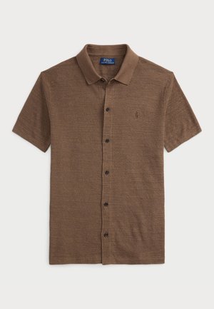 Polo marrón de manga corta con cierre de botones en la parte delantera y cuello, con un tejido texturizado sutil y un pequeño logo bordado en el pecho.