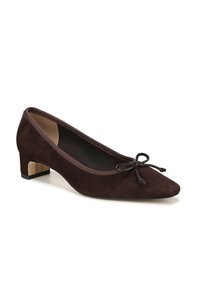 Pump in suede marrone con punta affusolata e un piccolo tacco a blocco. Presenta un dettaglio decorativo a fiocco e un bordo testurizzato attorno all'apertura.