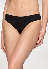 Mutande bikini nere realizzate in tessuto liscio. Presentano un design minimalista con un taglio a vita bassa e bordi senza cuciture per garantire comfort.