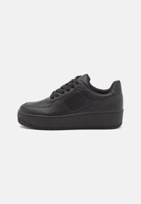 Sneaker in pelle nera con parte superiore texturizzata, punta rotonda, lacci piatti, suola in gomma e dettagli di cucitura sottili sui lati.
