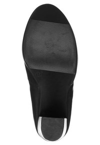 Svart sko sula med texturerad gummiyta, platt design och silverdetalj vid hälen. Slät finish och rundad tåform.
