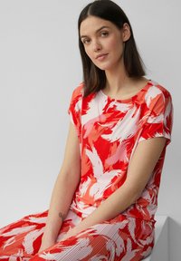 Rode en witte gestreepte top met korte mouwen, relaxte fit, gladde stof, met een gedurfde penseelstreekontwerp; gedragen met bijpassende gestreepte broek.