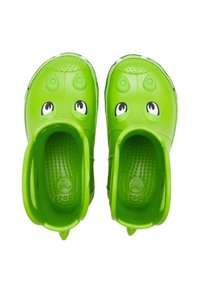Zuecos infantiles verdes con diseño de rana, que presentan punta redondeada, ojos prominentes, superficie texturizada y orificios de drenaje para el agua.