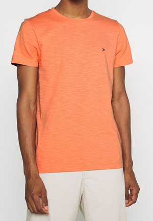 T-shirt a maniche corte, con collo a giro, di cotone arancione brillante, con un piccolo logo sul petto sinistro. Tessuto morbido, vestibilità rilassata.