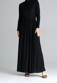 Zwarte jurk met lange mouwen, hoge halslijn, getailleerde taille en uitlopende rok. Soepele, rekbare stof met een minimalistisch ontwerp.