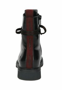 Schwarze Leder-Ankle-Boots mit strukturierter Oberfläche, Reißverschluss, und bordeauxrotem Akzentstreifen mit Markentext auf der Rückseite. Gummisohle.