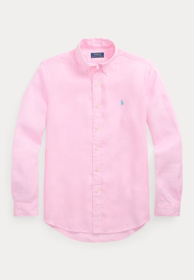 Világos rózsaszín, hosszú ujjú, gombos ing, gombos gallérral és a bal mellrészen kék Polo Ralph Lauren logóval hímzett.