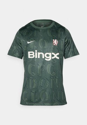 Maglia Nike verde con un motivo testurizzato e una grande scritta. Logo "Bingx" bianco posizionato al centro, con uno stemma rosso del club sulla sinistra.