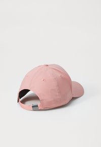 Lyserød baseballkasket med en rund krone, blødt stof og en justerbar rem bagpå, der har en lille hardwaredetalje.