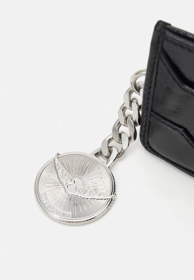 Black leather wallet featuring a silver chain and a round metallic charm with a winged design and radial lines texture.