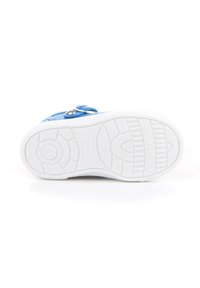 Suela de zapatilla textil azul con una suela de goma blanca que presenta un patrón de agarre texturizado y un acento metálico para el cierre de la correa.