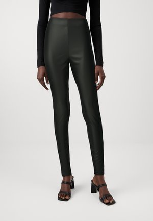 High-waisted, dark green leggings with a glossy finish. The tailored fit features smooth, stretchy material and minimal seams for a sleek look.