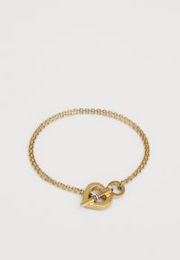 Gullkjedearmbånd med hjerteformet clasp med gravert detaljer og en liten sirkulær anheng. Glatt tekstur med polert finish.