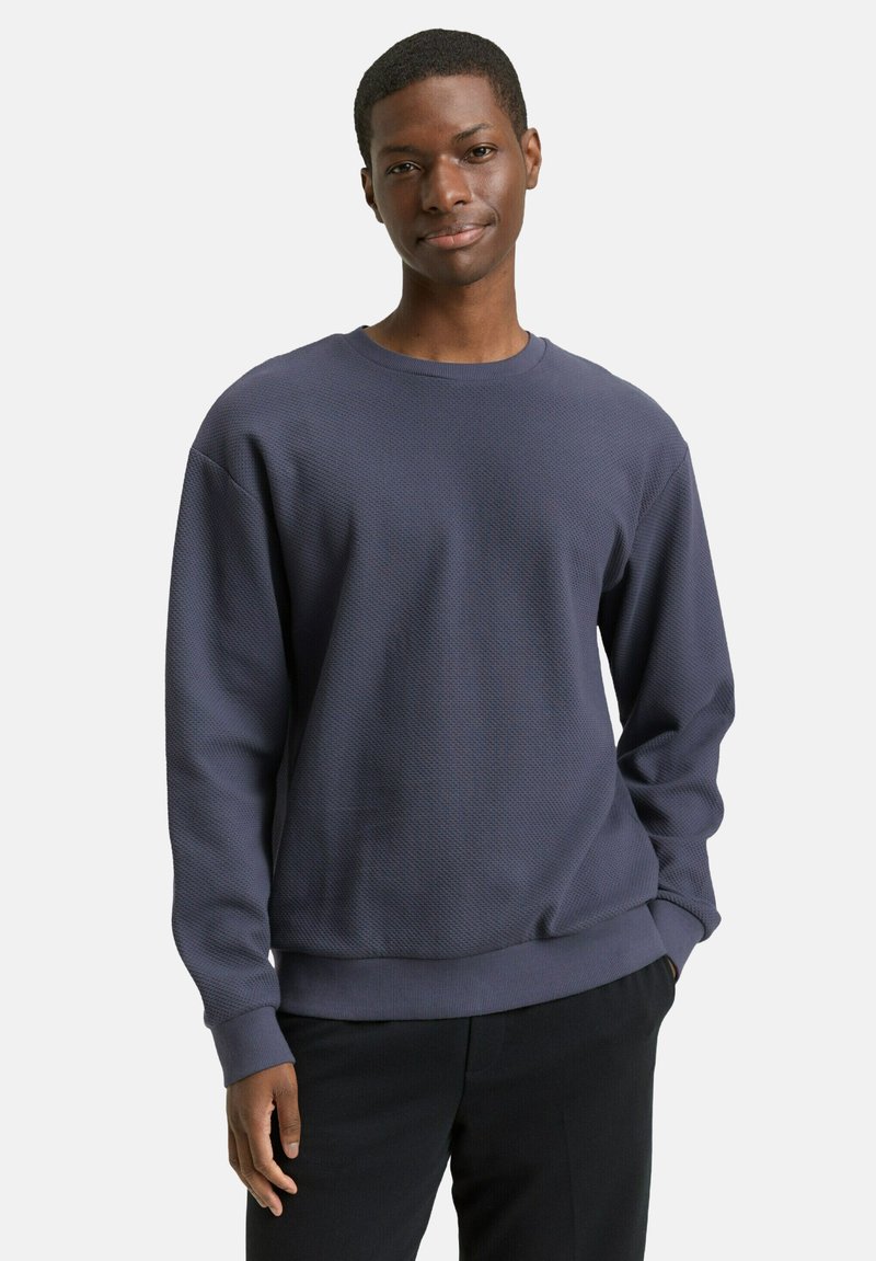 Marineblauer, strukturierter Pullover mit rundem Ausschnitt und langen Ärmeln. Verfügt über gerippte Bündchen und Saum, glatten Stoff mit einem dezenten Muster.