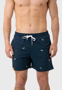 Pantaloni da bagno navy con cintura elastica e cordino bianco. Presentano accenti ricamati colorati. Materiale leggero e a rapida asciugatura.