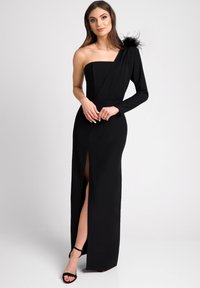 Czarna sukienka z asymetrycznym dekoltem na jedno ramię, z długim rękawem, rozcięciem z przodu i akcentem z piór. Wykonana z gładkiego, sztywnego materiału.