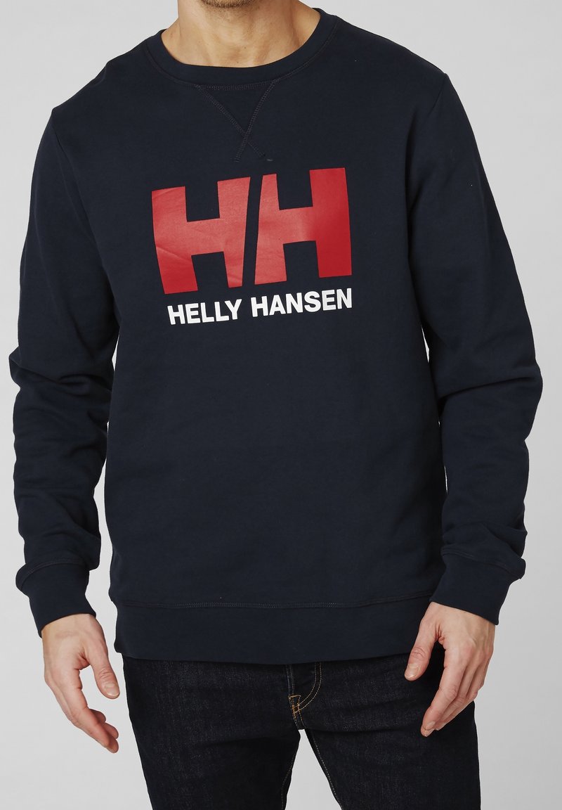 Sweat-shirt bleu marine en coton, avec un grand logo "HH" rouge et blanc et le texte "HELLY HANSEN" sur le devant. Conception classique à col rond.