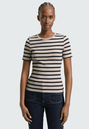 Striped short-sleeve top in beige and navy, ribbed texture, round neckline, fitted design, paired with dark jeans.