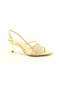 Sandal in oro con tacco angolato, cinturini decorati con perline, punta aperta e texture liscia sulla soletta. Fascetta alla caviglia regolabile.