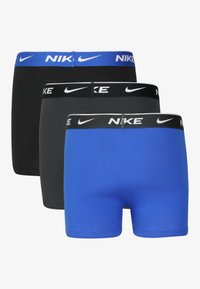 Drie paar Nike boxershorts: één blauw, één zwart en één donkergrijs. Elk paar heeft een merk-elastische tailleband met een contrasterend logo.